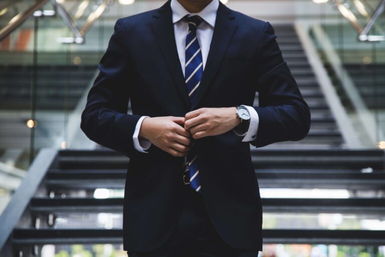 Homem de terno, gravata e relógio, representando um empreendedor