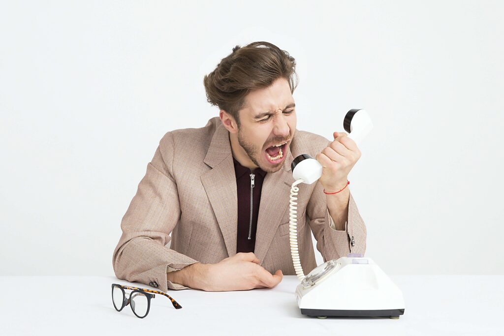 Homem gritando com o telefone durante uma venda.