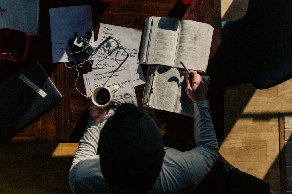 Homem segurando caneca de café enquanto estuda